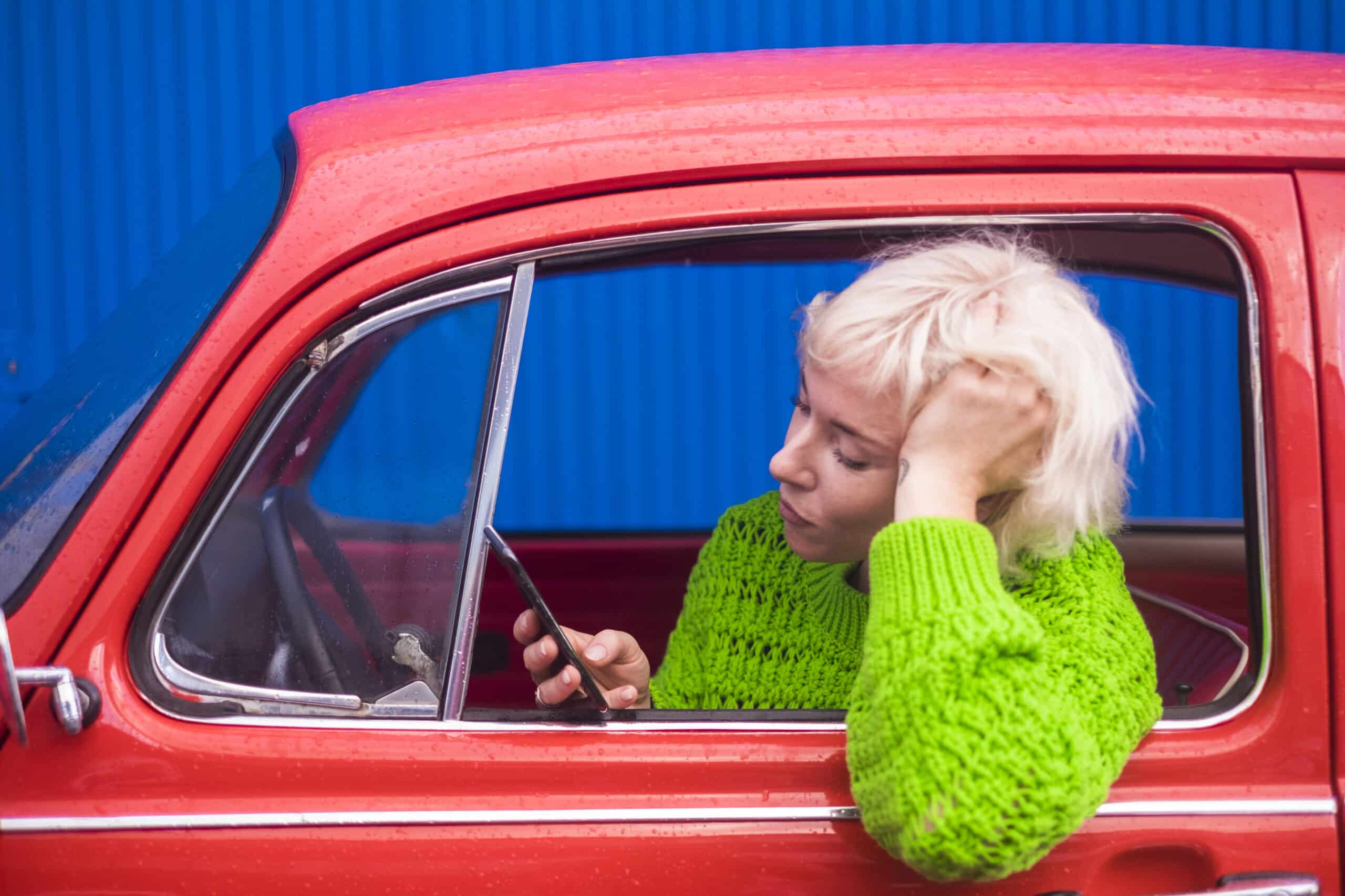 A woman on her phone whilst waiting in car