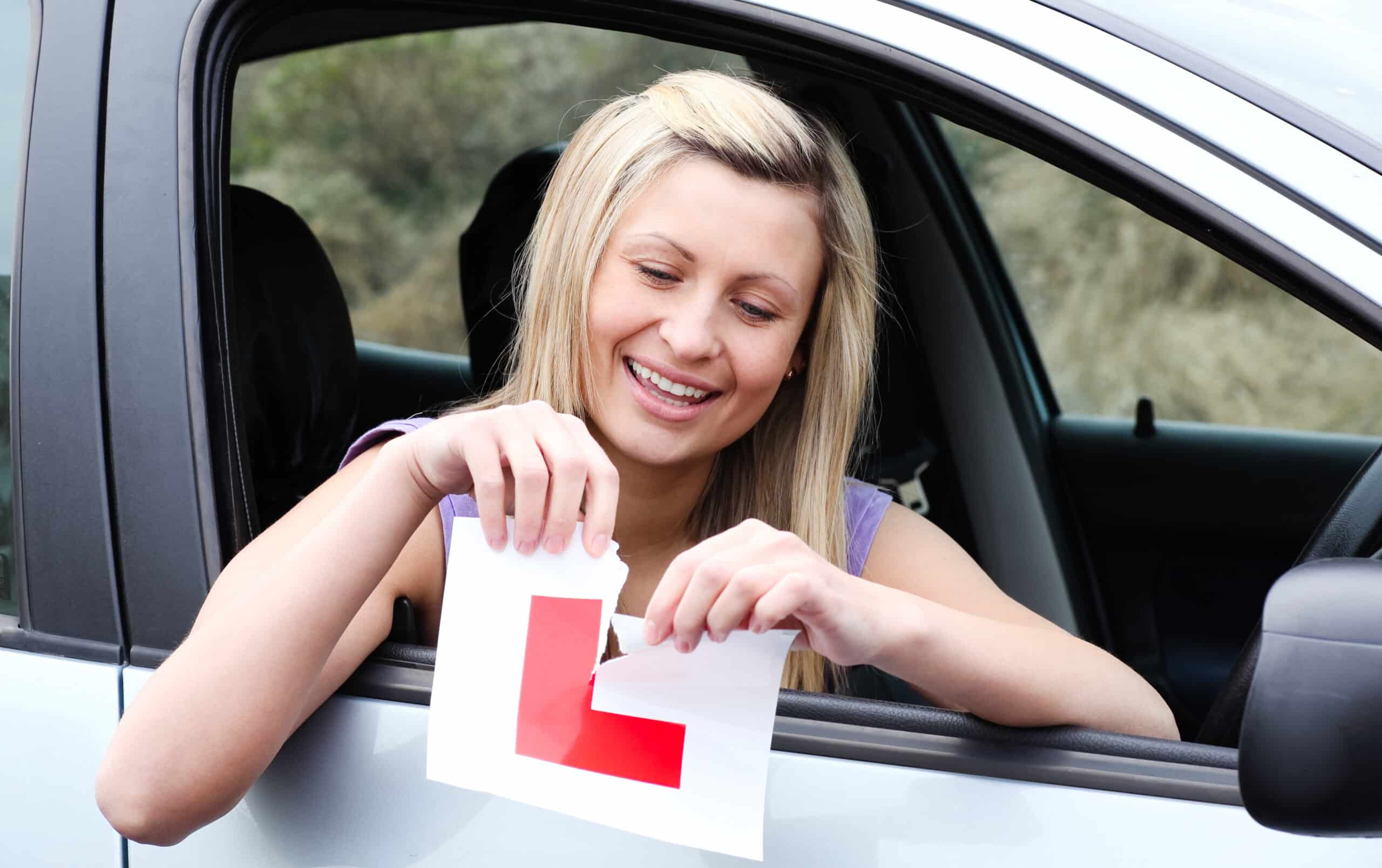 Woman tearing up her learner sticker